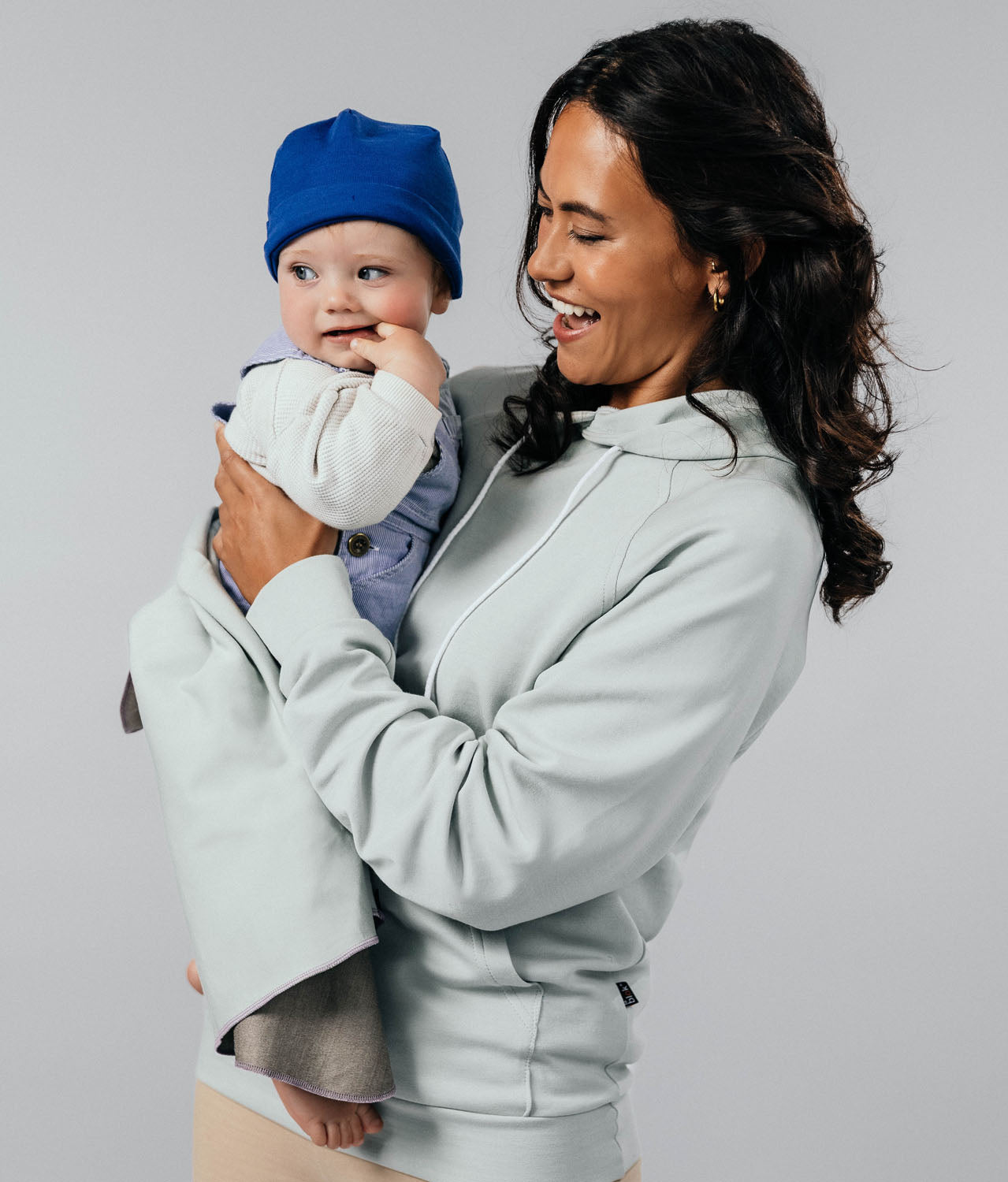 Woman holding a baby wrapped in EMF blanket Leblok