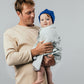 Man holding a baby wrapped in an EMF shielding blanket Leblok
