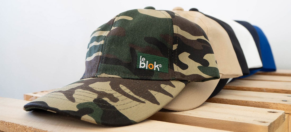 EMF protection caps Leblok in all colours lined up on a bench