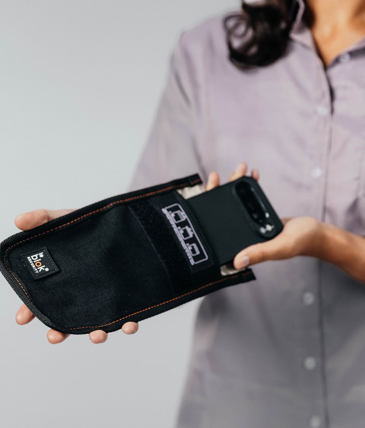 Person placing a phone in Faraday bag from Leblok Security
